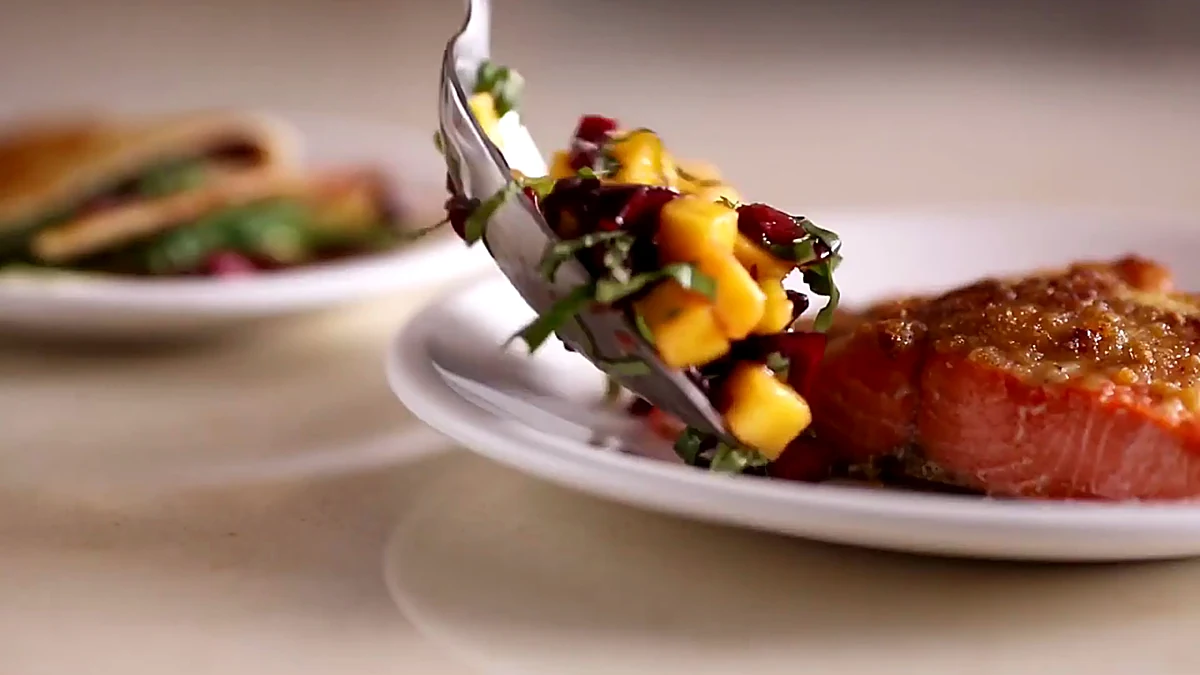 Mango cherry topping spooned over salmon