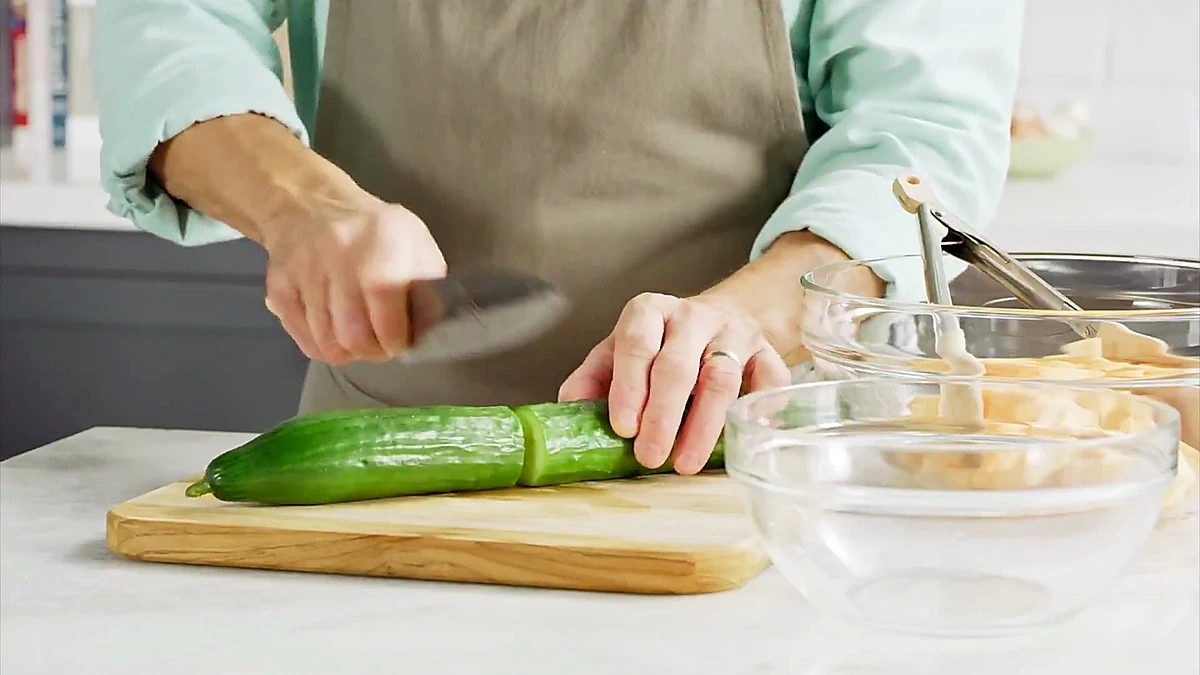 Cucumber being sliced for melon cucumber salad