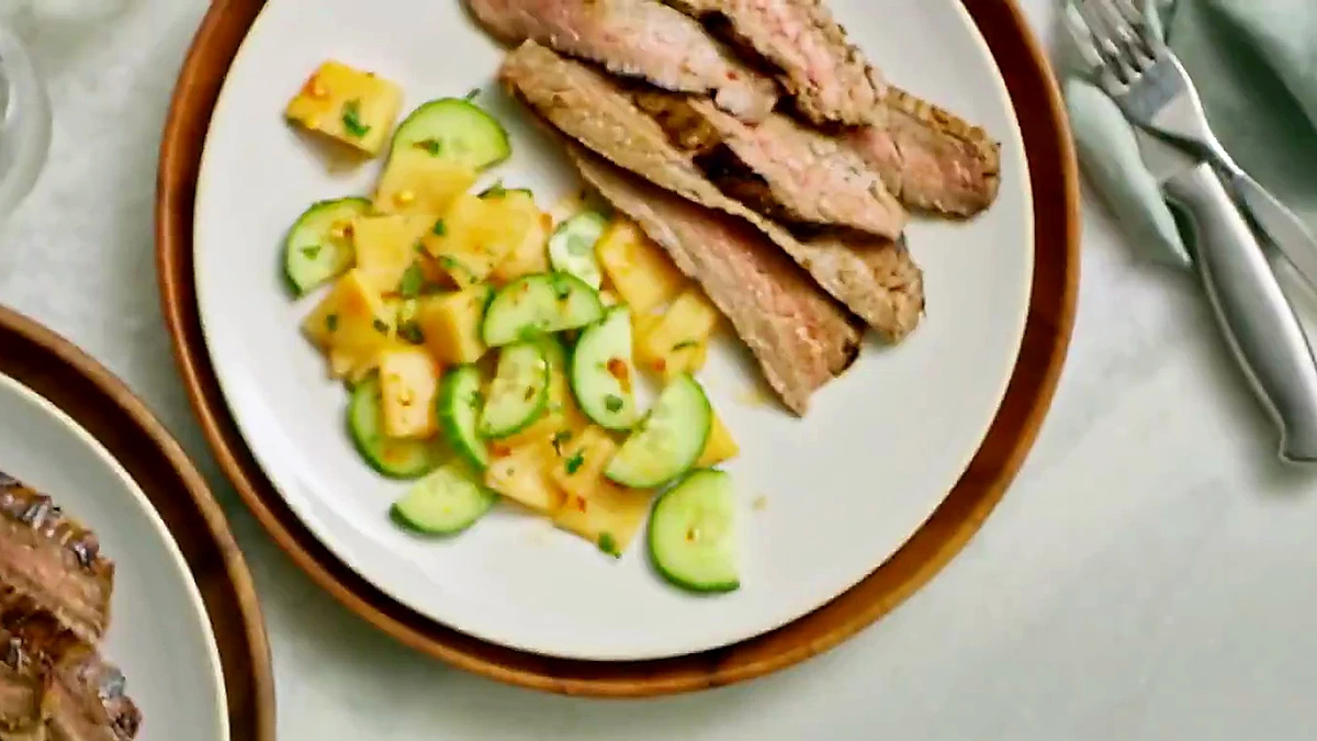 Chili herb steak plated with melon cucumber salad