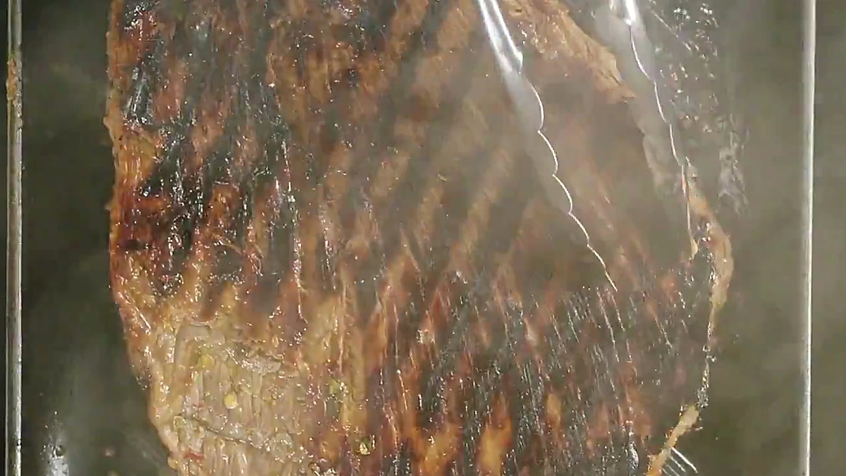 Chili herb steak cooking on a grill pan