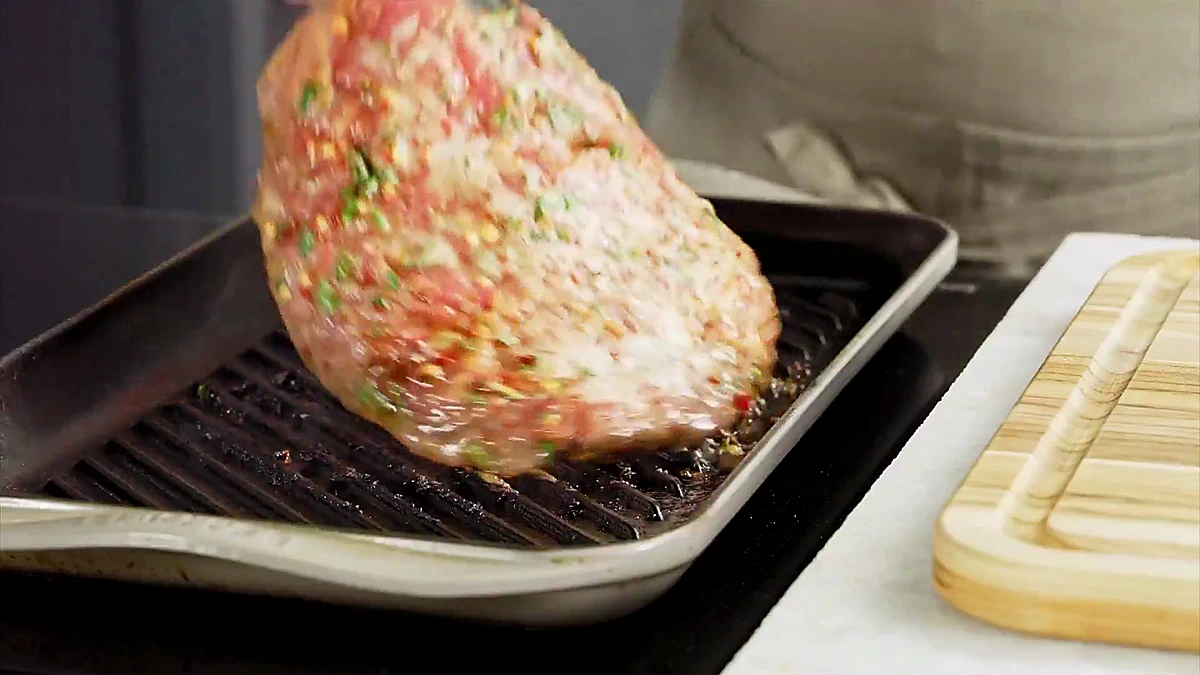 Marinated flank steak placed on a hot grill pan