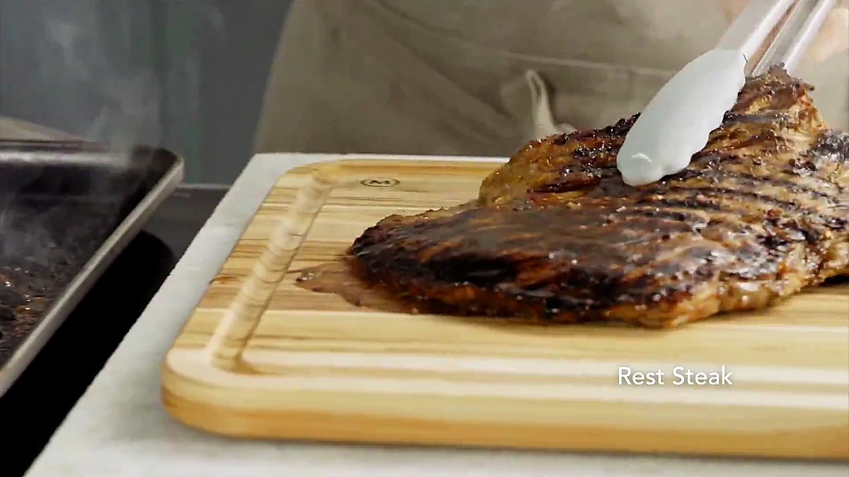 Grilled flank steak resting on a cutting board