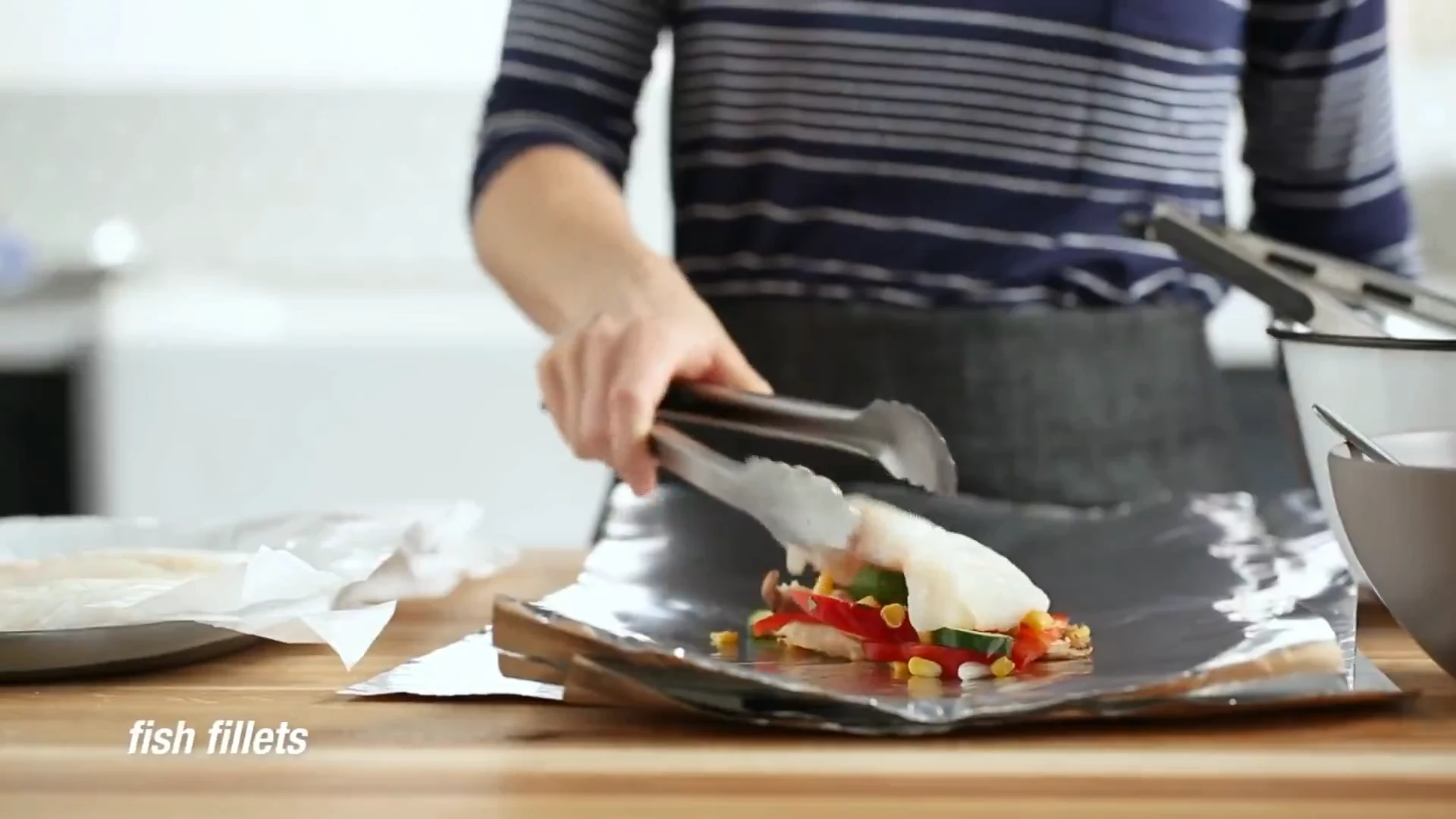Fish fillet set on top of the vegetables in the foil