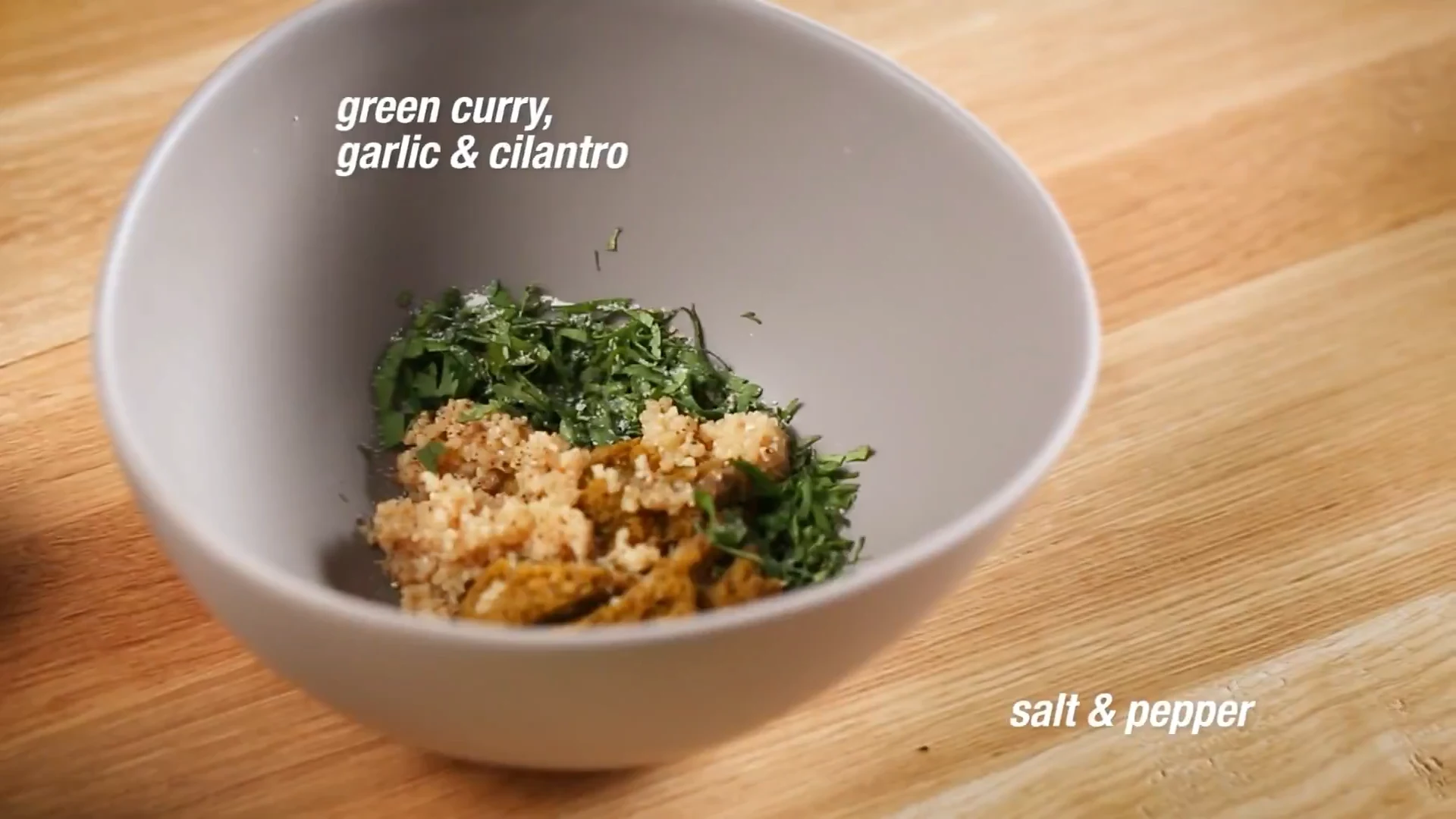 Green curry paste, garlic, and cilantro in a small bowl