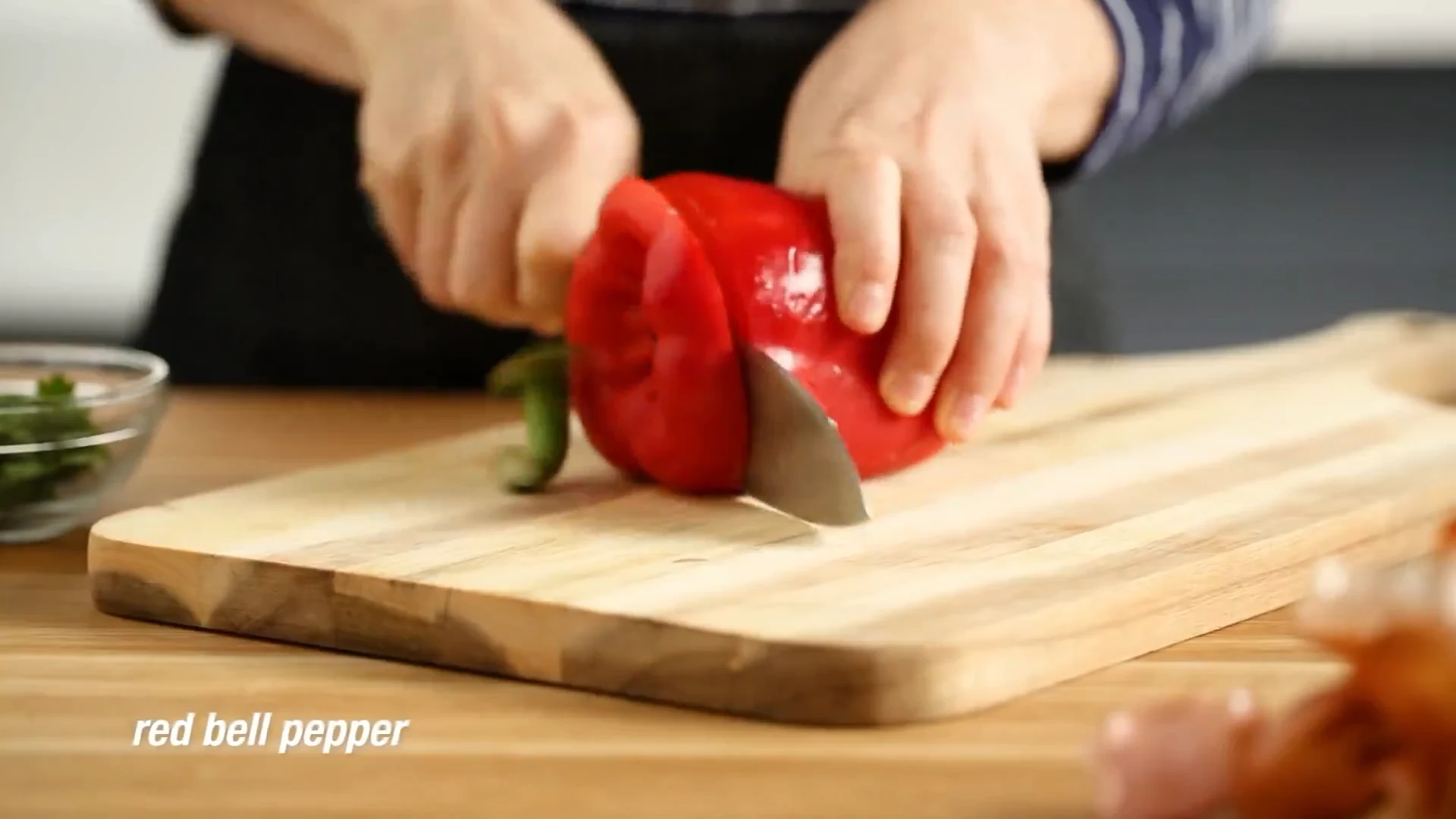 Red bell pepper being sliced into thin strips