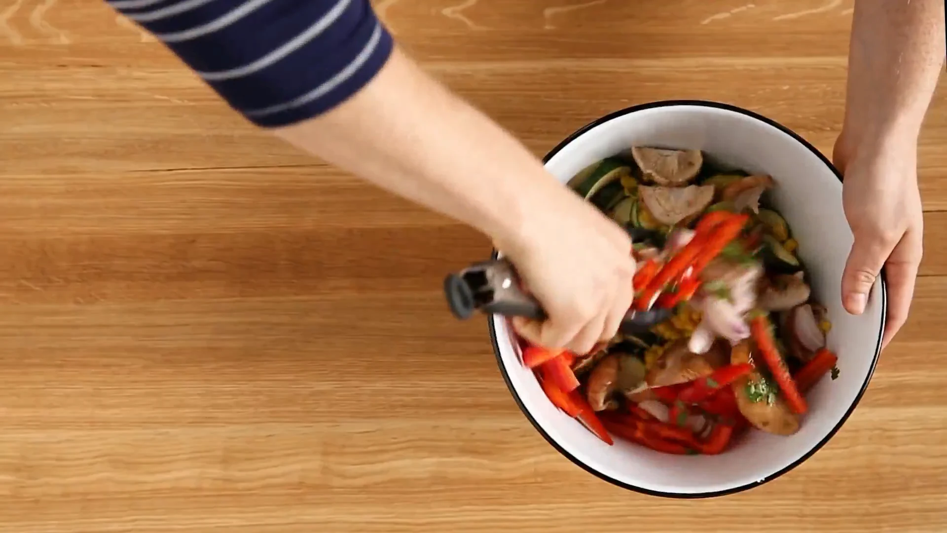 Vegetables tossed in seasoning with tongs
