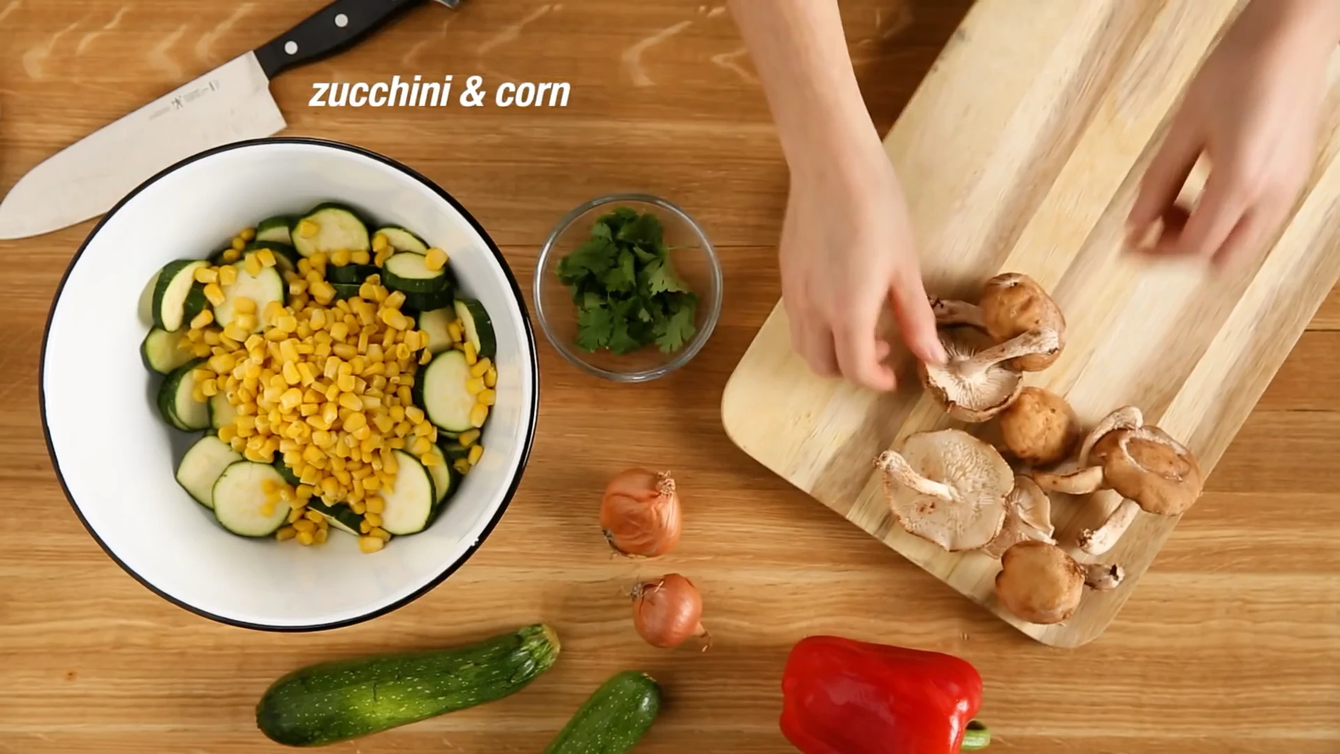 Sliced zucchini and corn in a white mixing bowl