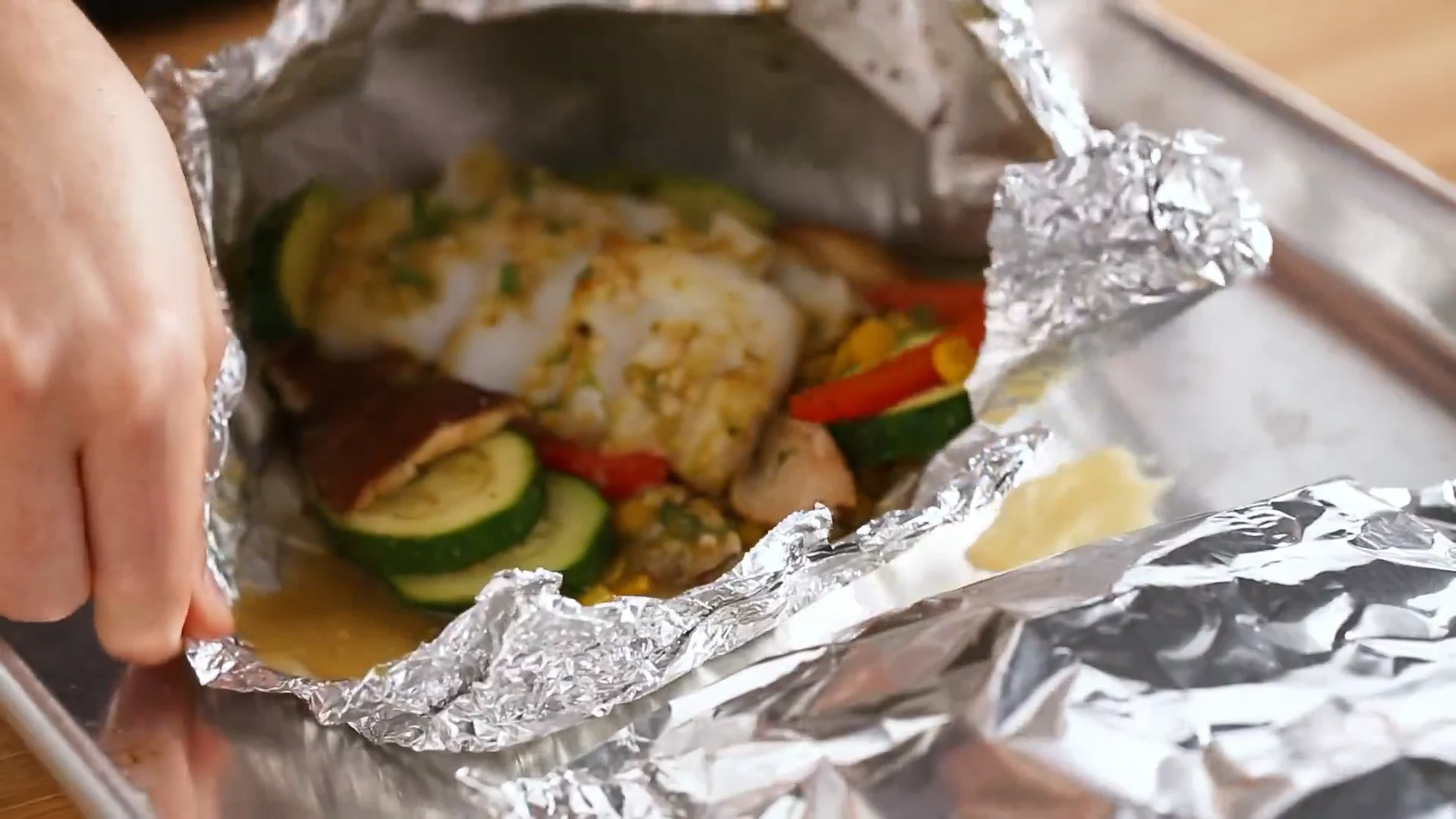 Coconut curry fish foil pack opened on a sheet pan