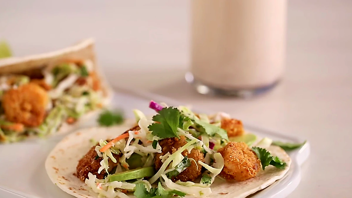 Close angle of crispy Baja shrimp tacos with creamy slaw