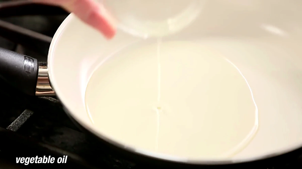Vegetable oil poured into a saute pan for frying shrimp