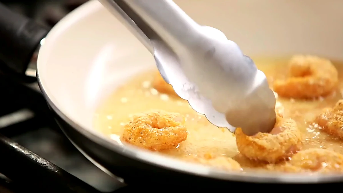 Breaded shrimp starting to fry in hot oil