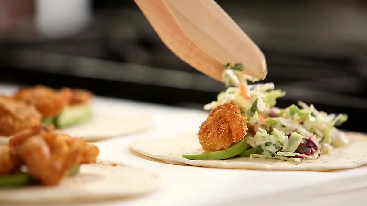 Creamy lime slaw spooned over crispy shrimp tacos