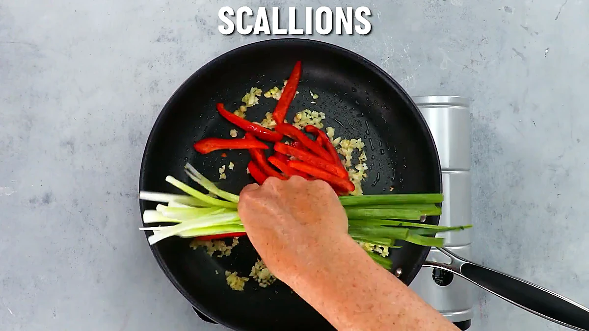 Scallions and red pepper added to the garlic