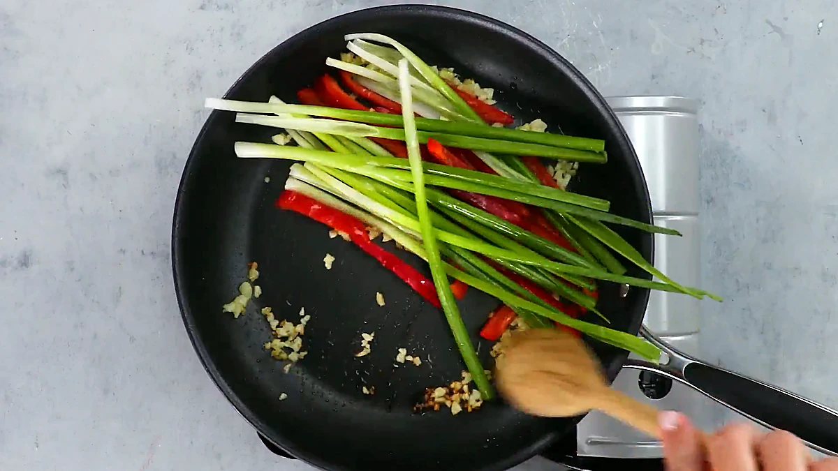 Scallions and red pepper stir fried in the pan