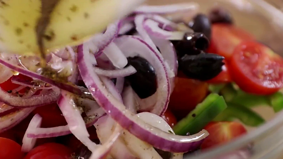 Dressing poured over Greek salad