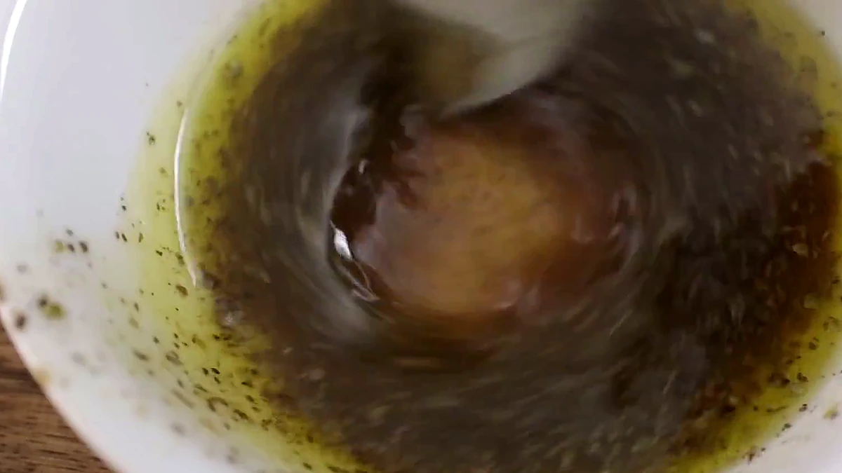 Greek salad dressing stirred with oregano and pepper