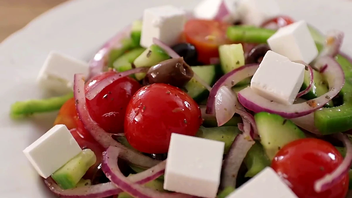 Feta cubes added to plated Greek salad