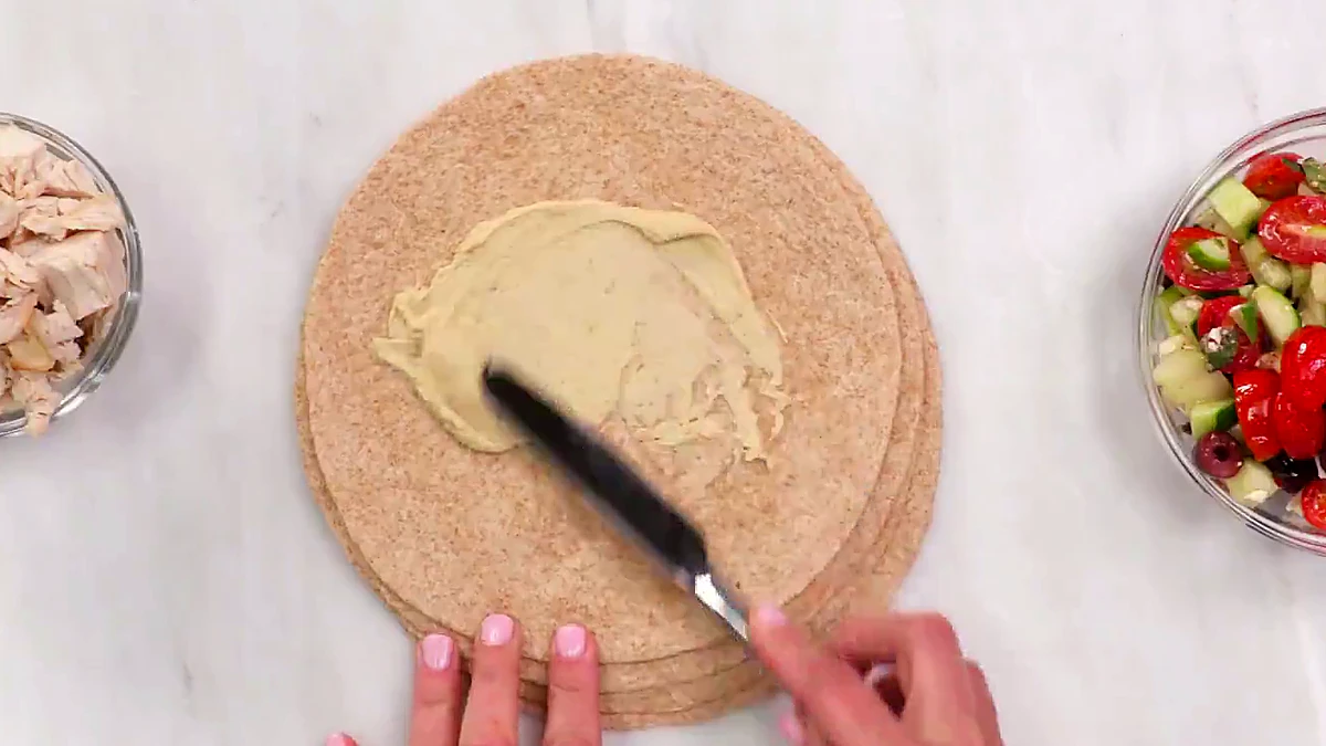 Hummus spread on a whole wheat tortilla
