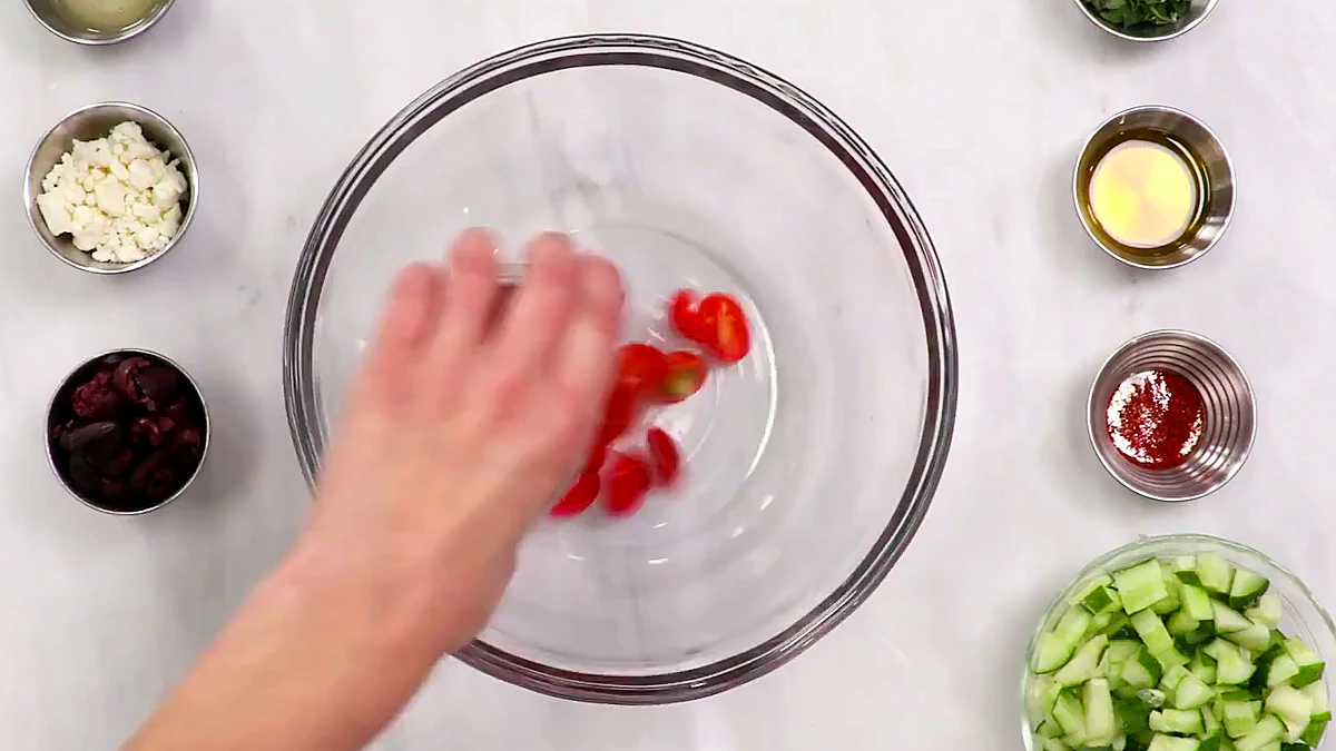 Grape tomatoes added to a bowl