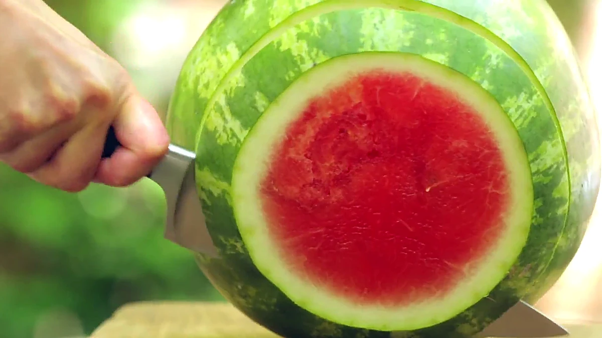 Watermelon being cut into a thick round