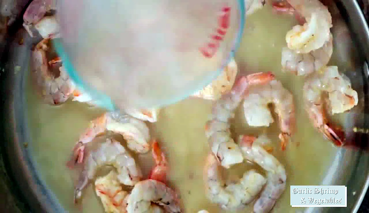 Chicken broth mixture poured into shrimp skillet