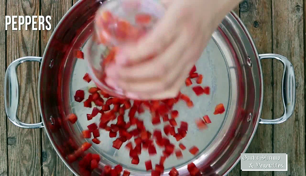Diced red peppers added to a skillet