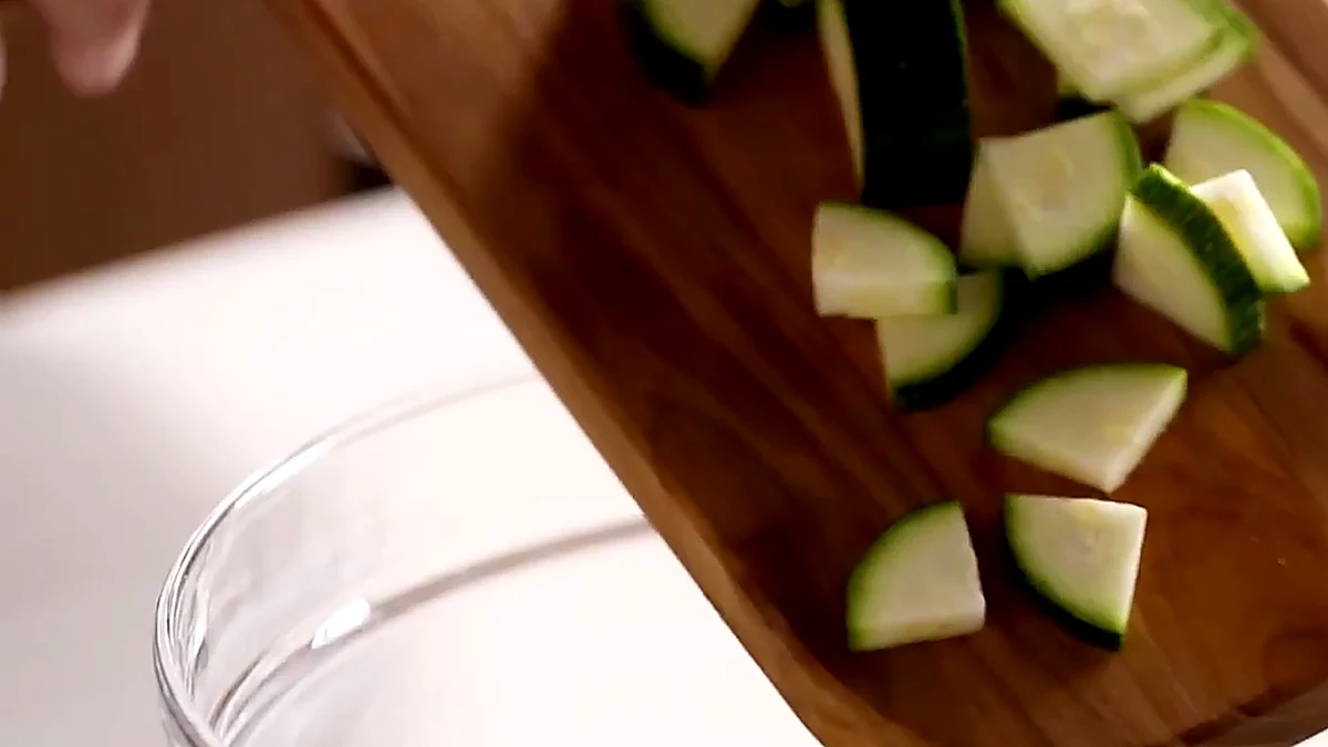 Chopped zucchini being added to the corn salad