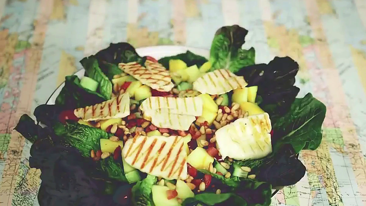 Grilled halloumi slices set on mango pancetta salad
