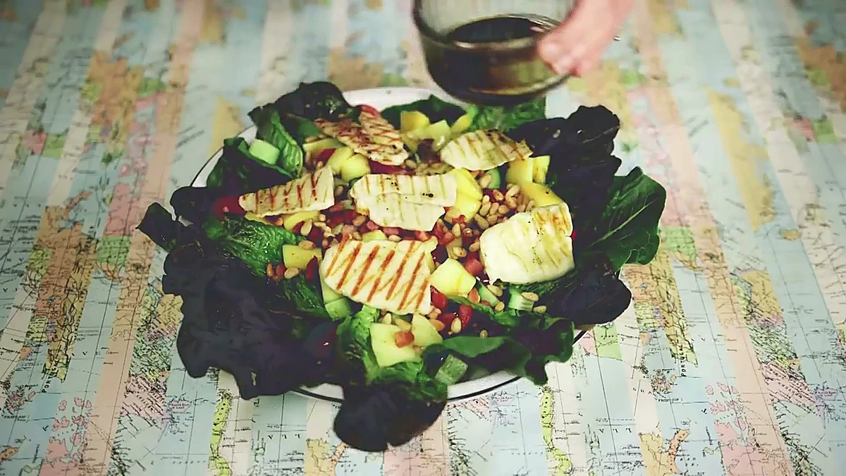 Mango pancetta salad with dressing poured over the top