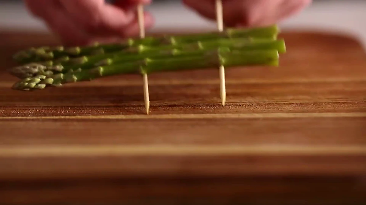 Close view of an asparagus raft held by skewers