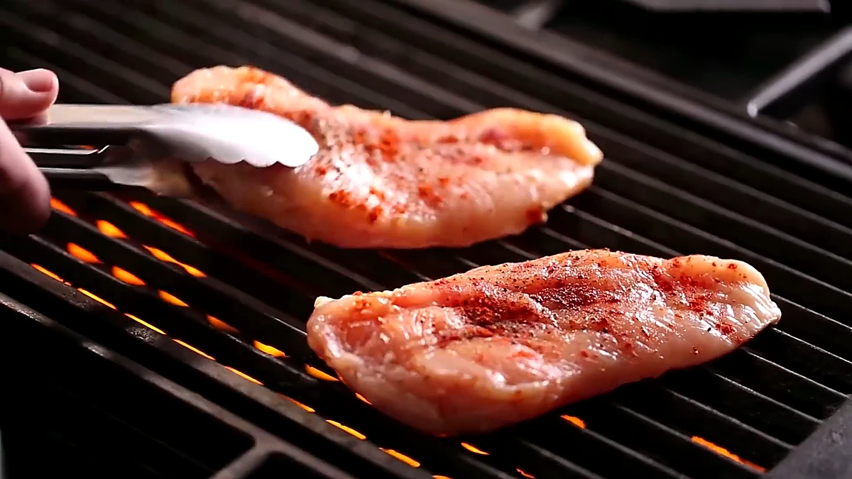 Seasoned chicken breasts placed on the grill