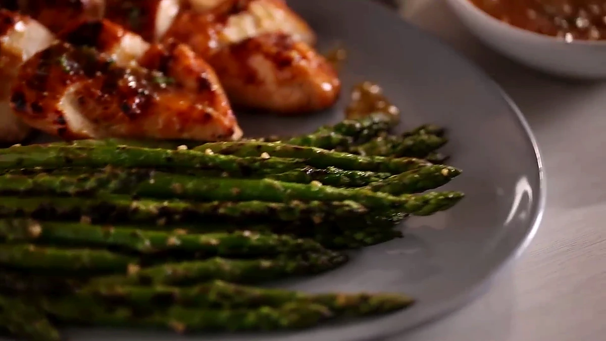 Finished peach chicken with chargrilled asparagus and extra glaze