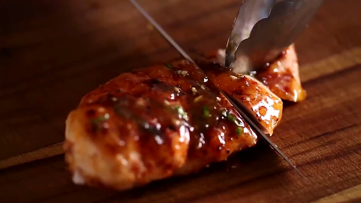 Glazed peach chicken being sliced
