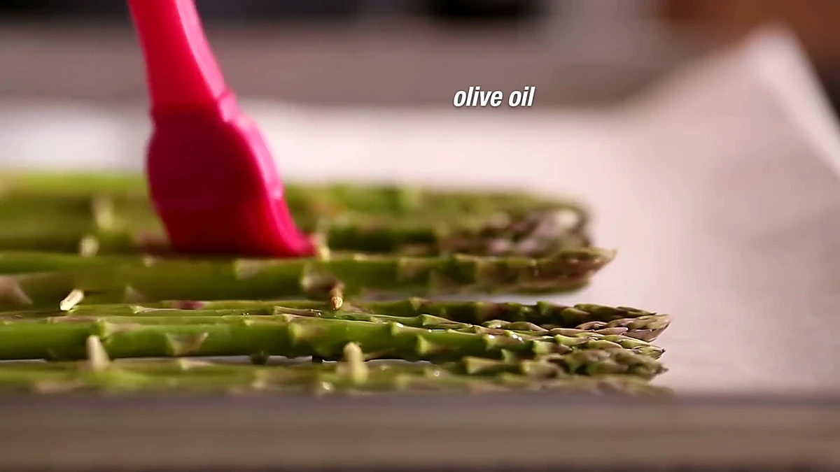 Olive oil brushed over asparagus skewers
