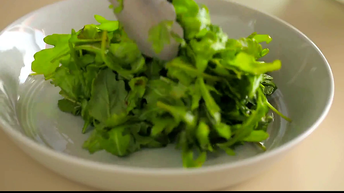 Dressed arugula spread on a serving plate