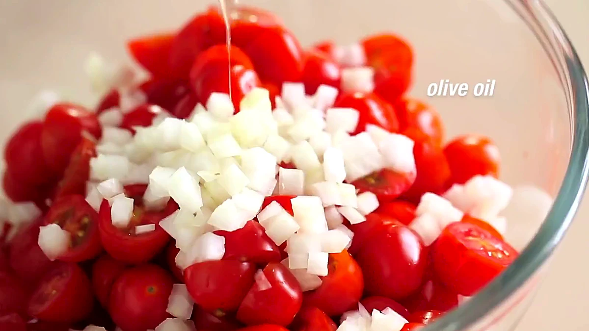 Olive oil added to tomatoes and onions