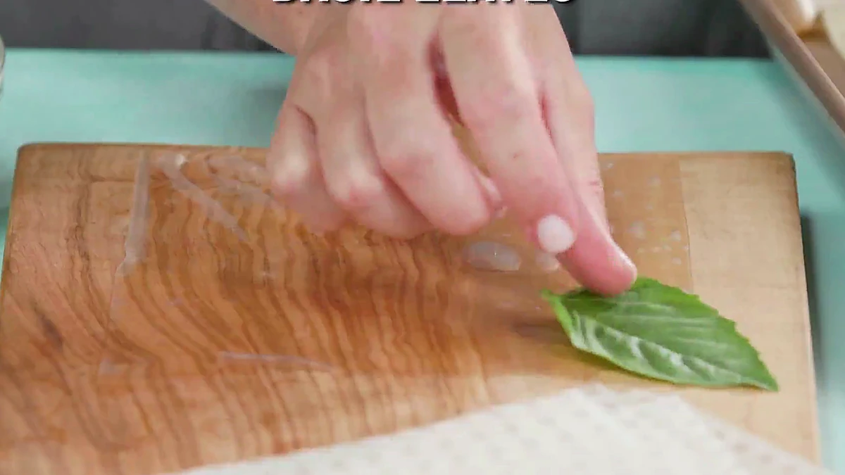 Basil leaves placed on a rice paper wrapper