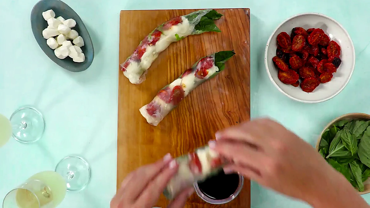 Finished roasted tomato Caprese summer rolls on a board