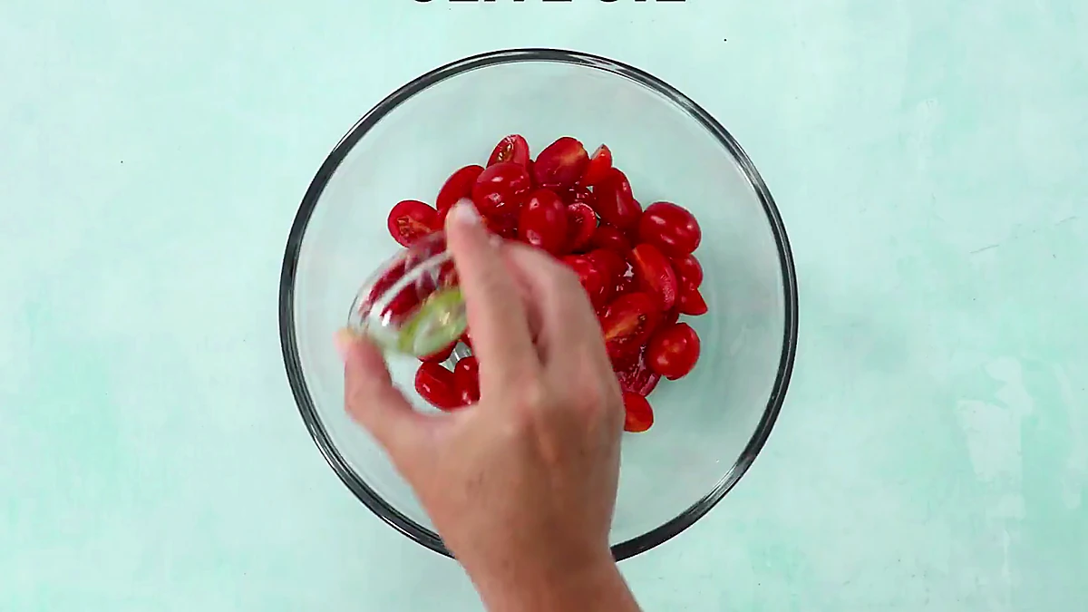 Olive oil poured over halved grape tomatoes