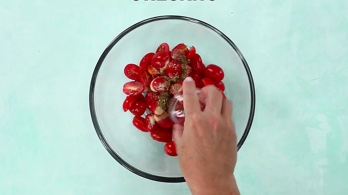 Oregano added to seasoned grape tomatoes