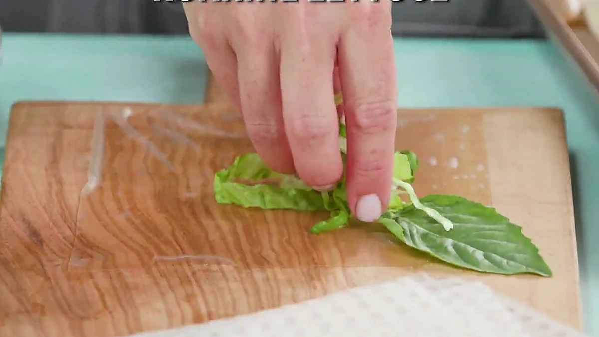 Romaine lettuce added over basil on rice paper