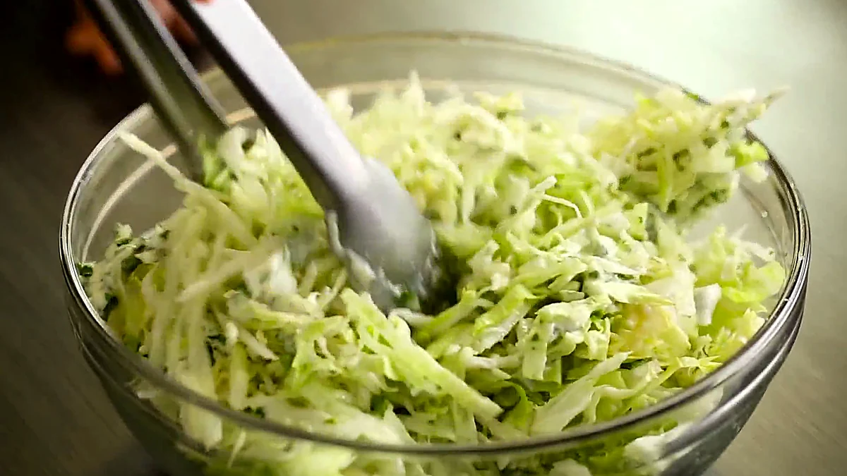 Dressed lettuce tossed with tongs