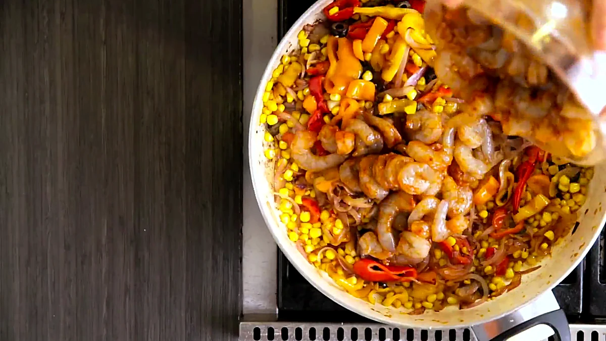 Seasoned shrimp added to skillet vegetables