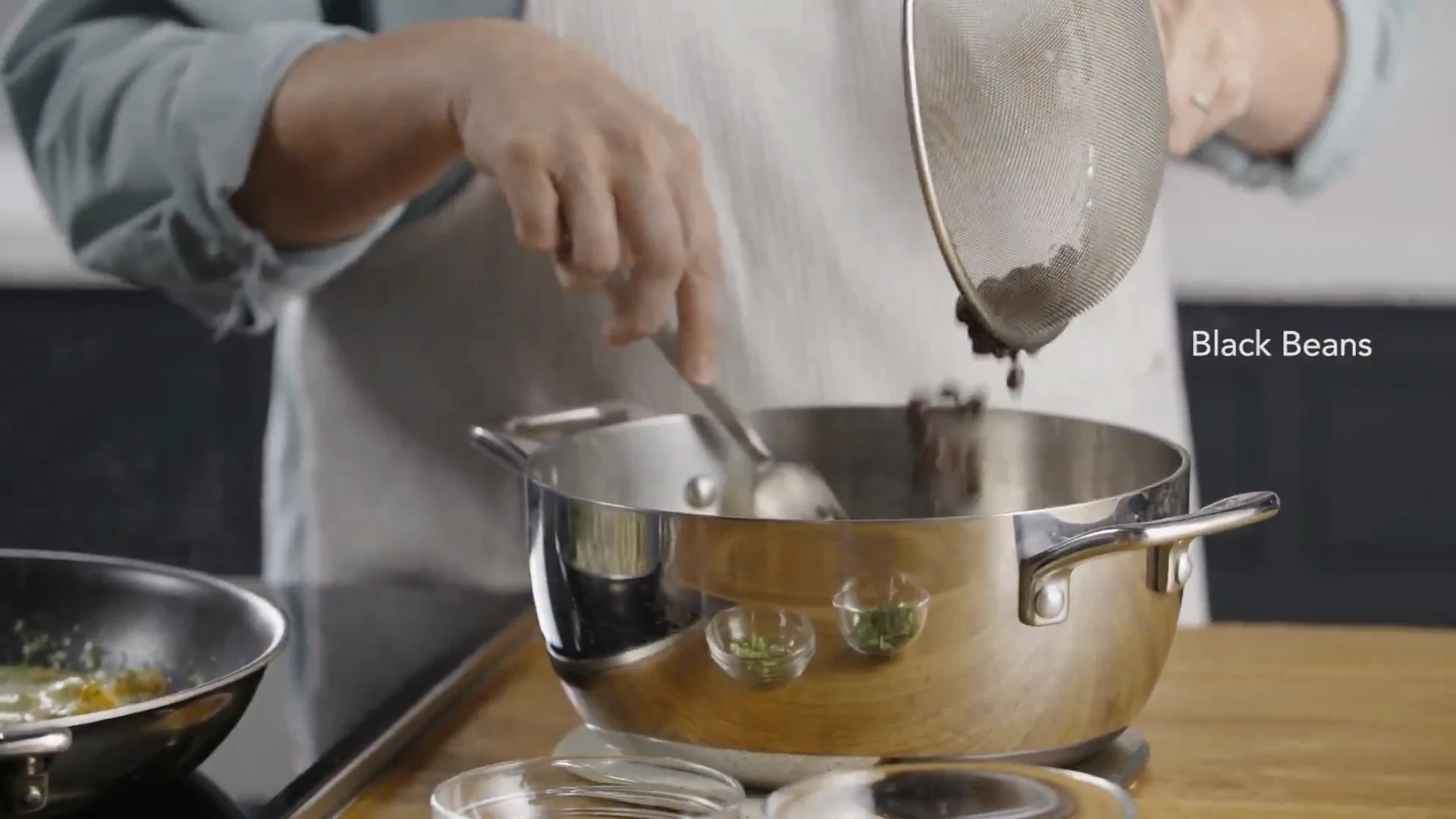 Black beans being added to the cooked rice