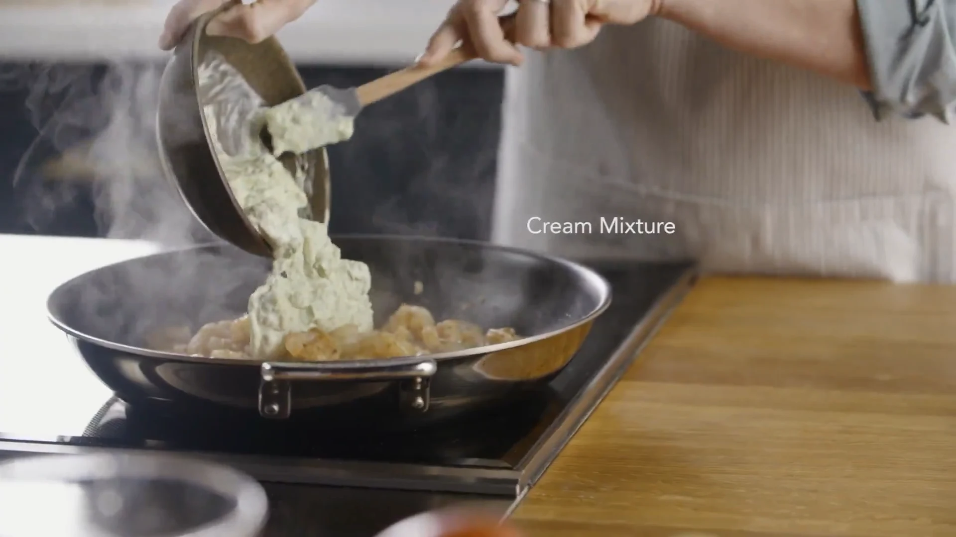 Verde cream mixture being scraped into the skillet with shrimp