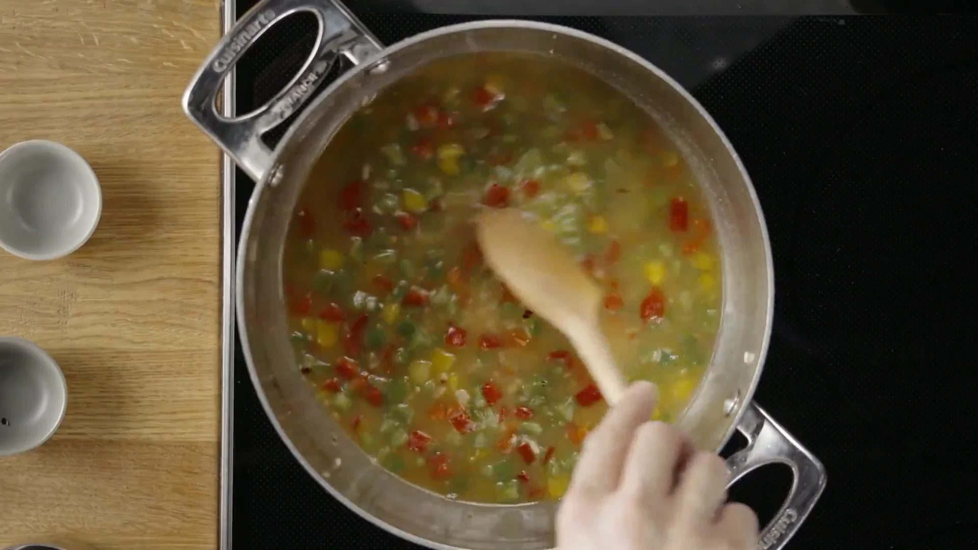 Rice simmering with peppers in chicken stock