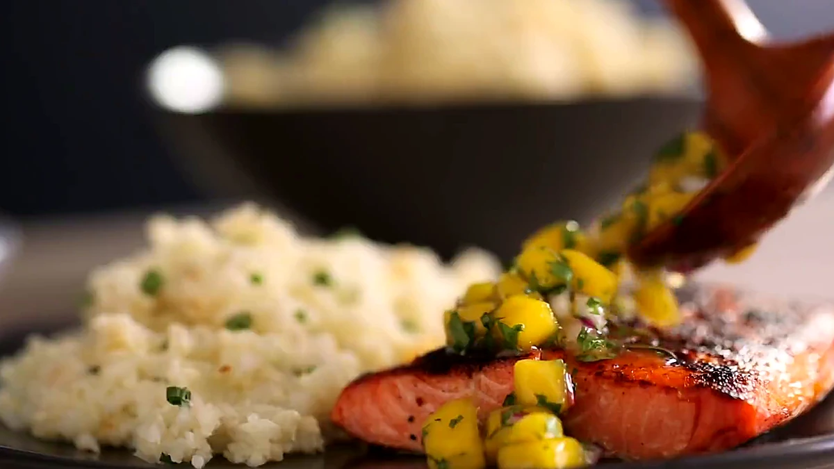Mango salsa spooned over grilled salmon