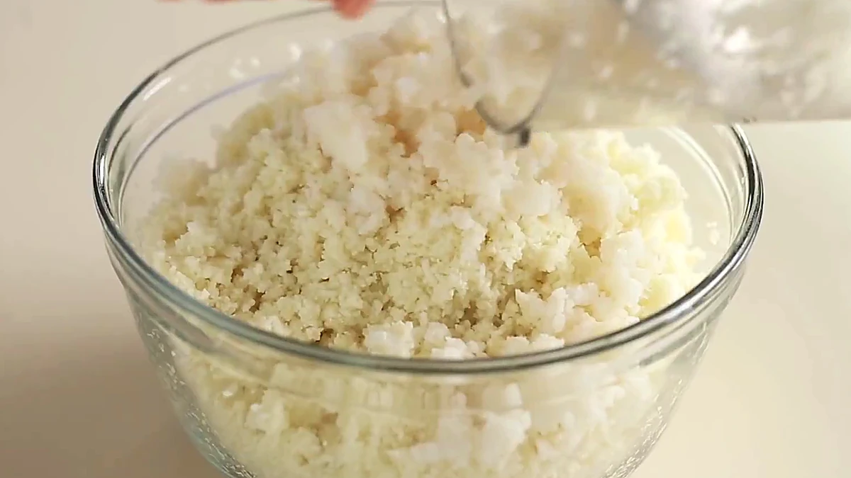 Riced cauliflower and hominy mixed in a bowl