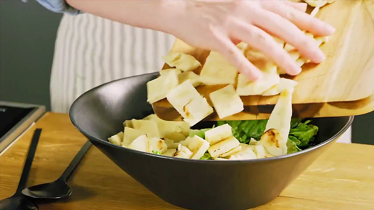 Naan pieces added to dressed romaine