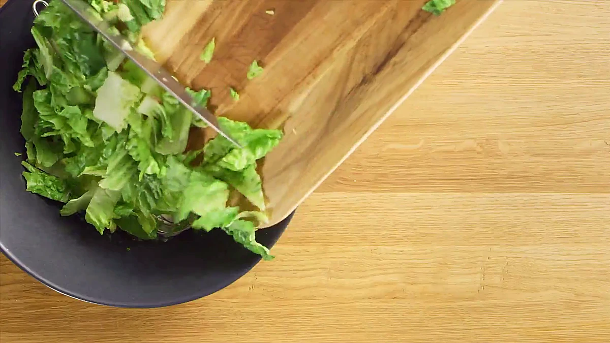Chopped romaine added to the dressing bowl